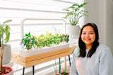 Indoor gardener posing with the Click & Grow Smart Garden 9 in her home.